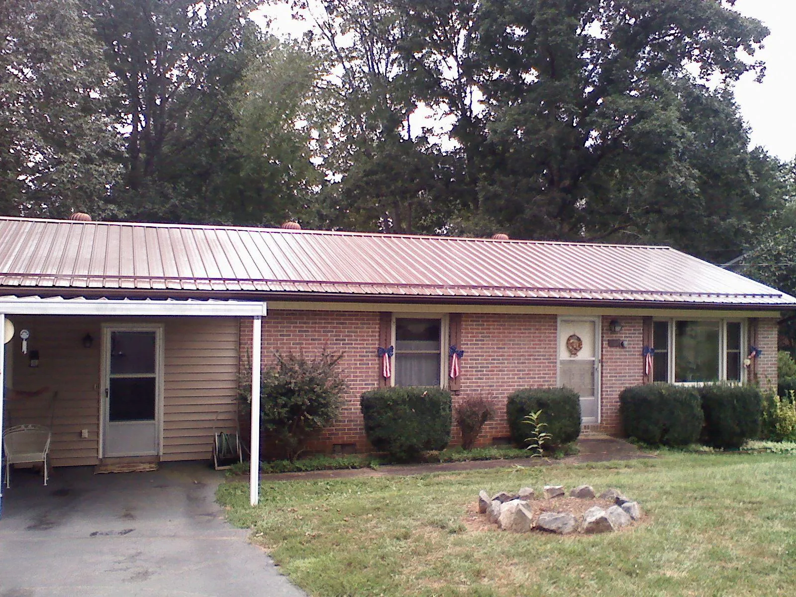 Bronze metal roof and carport on a brick ranch home — Roof Repair work by our crew in Bronwood